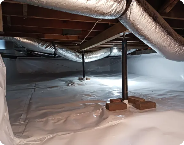 A crawl space sealed with a white vapor barrier